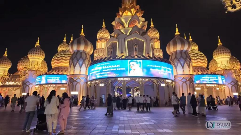 Crowds in front of the golden-domed Global Village entrance at night