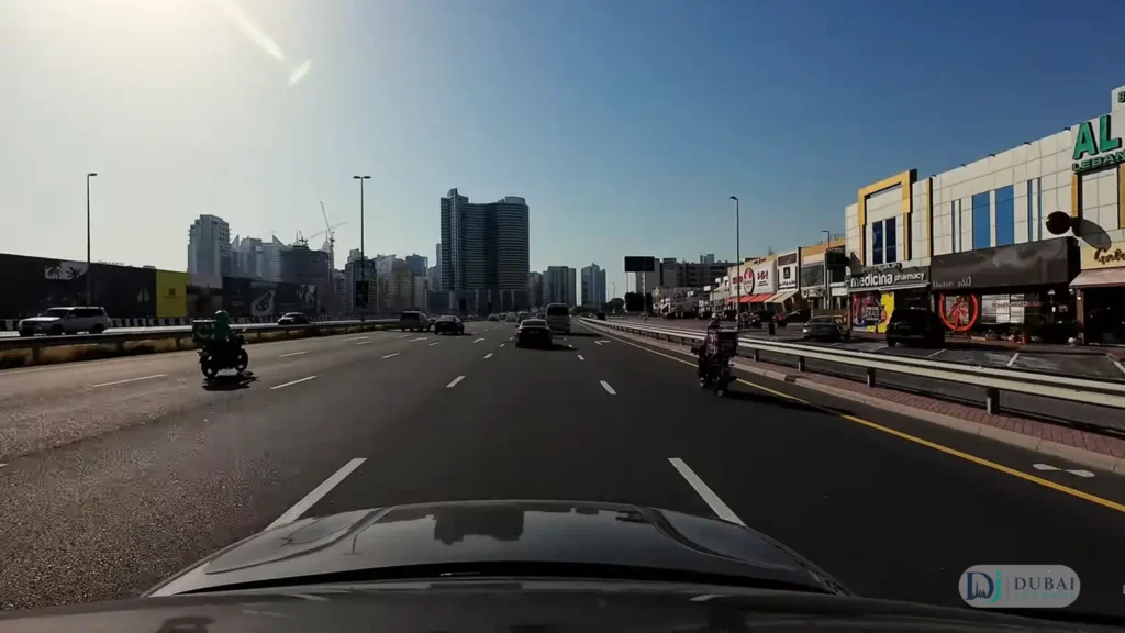 Driving through a Dubai street lined with local shops