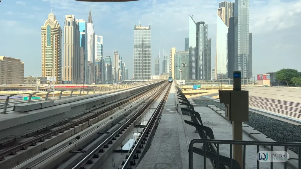 Dubai Metro elevated tracks toward skyscrapers during daytime hours
