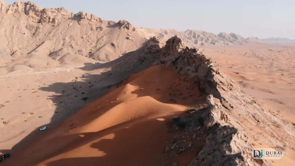 Fossil Rock rising above red sand dunes in the Mleiha desert, Sharjah