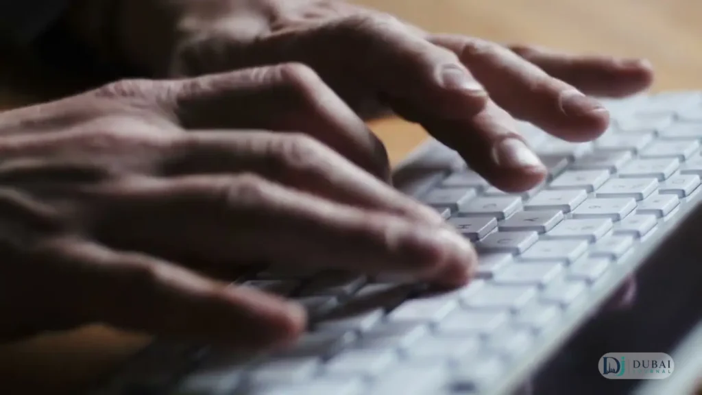 Hands typing on a laptop keyboard
