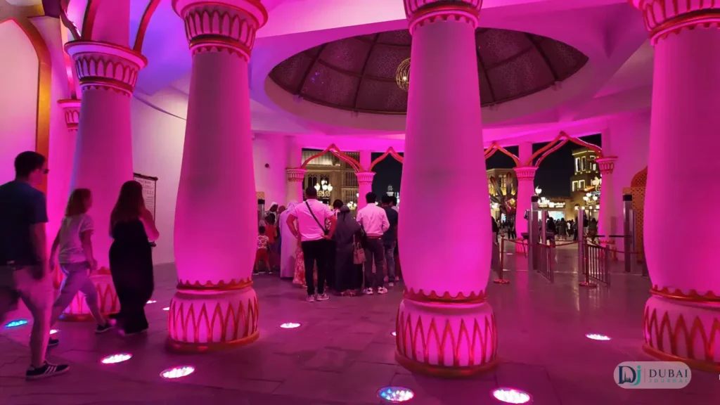 Pink-lit columned entrance hall of Global Village with evening visitors